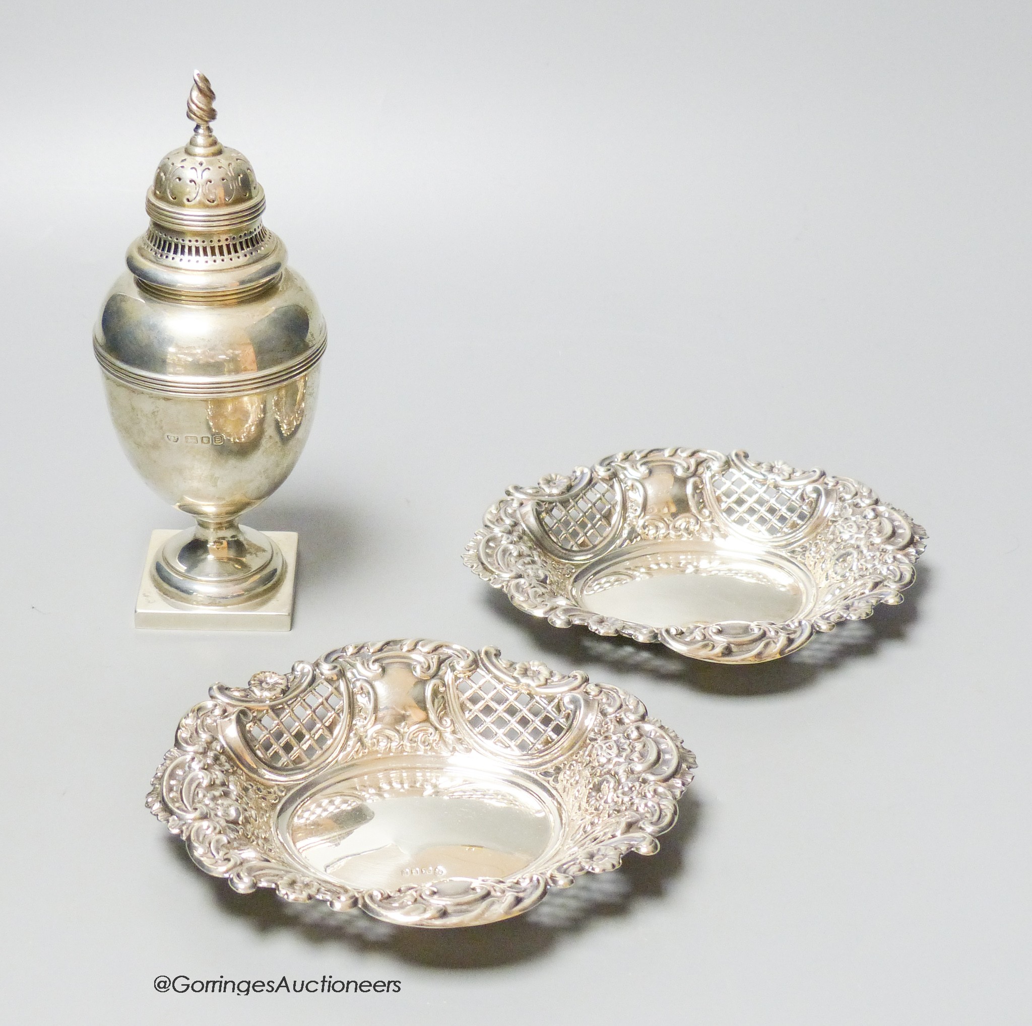 A George VI silver sugar caster, London, 1937, 18cm, together with a modern pair of pierced silver bon bon dishes, 13.5oz.